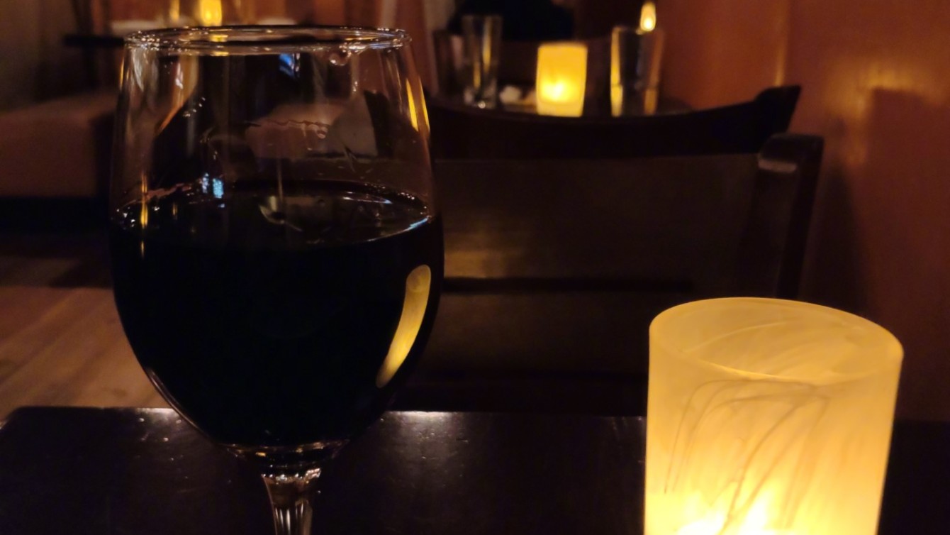 A glass of wine and a candle shot in a restaurant by the Mi Mix 3.